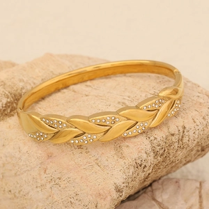 Bracciale a foglia dorata con zirconi scintillanti su una base di pietra grezza