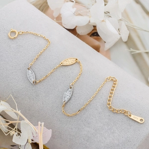 Macro shot of S925 silver leaf bracelet with gold two-tone finish on elegant display