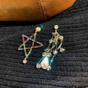 Close-up of star and moon earrings with colorful rhinestones and dangling fringe beads