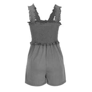 Detail of grey knitted romper featuring smocked bodice and ruffled strap design