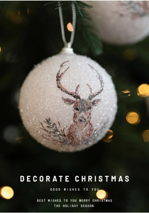 Close-up of white glitter Christmas ball with reindeer print hanging on tree