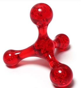 Close-up of a red transparent plastic massager with four nodes on a white background