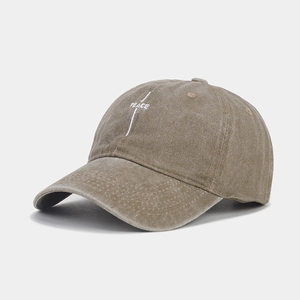 Detailed view of white letter embroidery and washed cotton texture on a vintage baseball cap