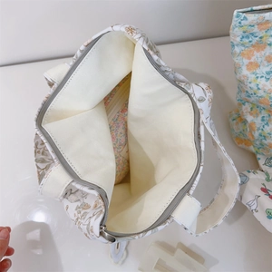 Detail view of the floral canvas bag showing spacious interior and secure zipper pocket