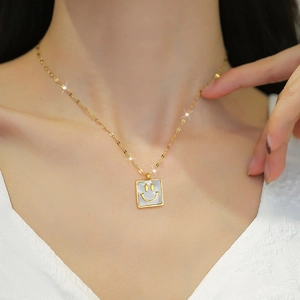 Minimalist square gold pendant necklace with white shell inlay and smiling face detail
