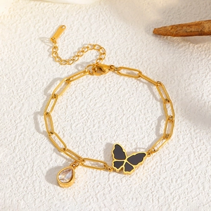 Détail du bracelet chaîne trombone dorée avec papillon noir et breloque goutte zircon