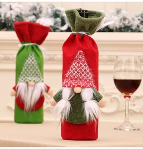Detail of red and green gnome wine bottle covers with white beards for holiday decor