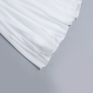 Détail de l'ourlet en maille blanche montrant le design plissé et les coutures précises