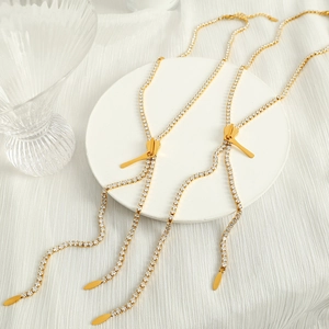 Elegant gold zipper pendant necklace with sparkling diamonds on a white display stand