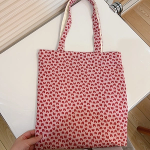 Detail view of pink floral canvas tote bag with heart pattern and durable dual shoulder straps
