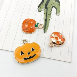 Détail de breloques citrouille d'Halloween avec émail orange et finition alliage doré