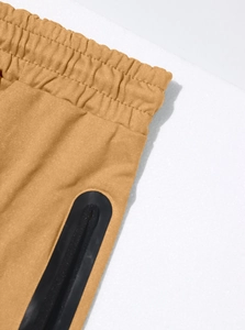 Macro detail of men's athletic joggers featuring elastic waistband and side zipper pocket