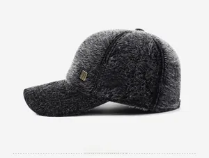 Detail of dark grey plush baseball cap featuring a premium golden metal logo plate