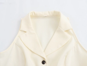 Detail view of a beige sleeveless vest with a lapel collar and classic front buttoning