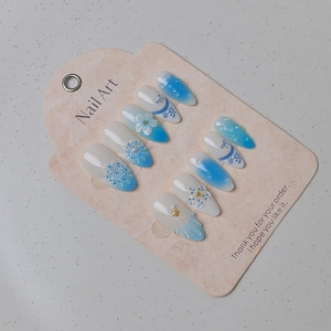 Detail of 3D ocean-themed press-on nails with blue gradient, shells, and pearls