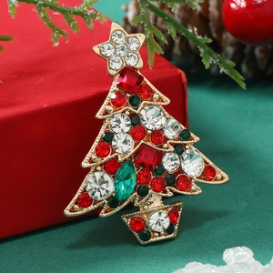 Christmas tree brooch with colorful rhinestones on red gift box with festive pine decor