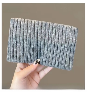 Detail of gray ribbed knit headband featuring a central black rectangular GRANK label