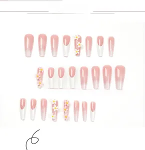 Macro detail of French tip press-on nails with 3D white daisies and pink gradient design