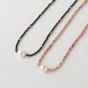 Elegant beaded necklace with natural black and pink stones and a central white pearl