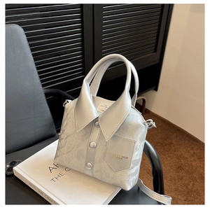 Macro shot of silver shirt-shaped handbag with button details and fine pleated texture