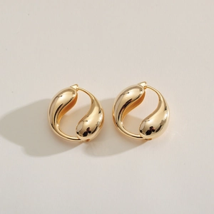 Minimalist gold teardrop earrings with a high-polished metallic finish on a cream background
