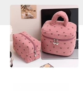 Detailed view of pink corduroy makeup bags with heart prints and heart zipper pulls