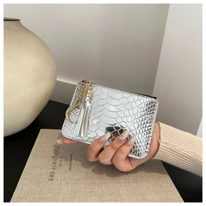Detailed close-up of a silver crocodile texture mini bag with elegant tassel and chain strap