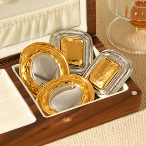 Macro shot of gold and silver hammered geometric jewelry in a velvet lined wooden box