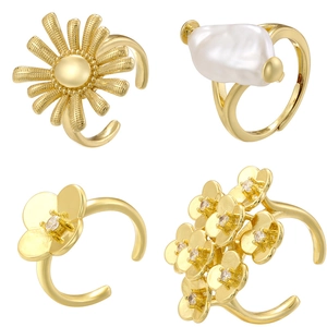 Detailed view of four vintage gold sunflower and baroque pearl adjustable open rings