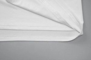 Macro shot of the white summer dress hem showing fine stitching and polyester fabric detail