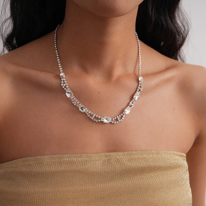 Detail shot of multi-layer silver necklace with square crystals worn by a model