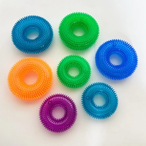 Detailed macro view of colorful TPR spiked ring chew toys for dogs with massage texture