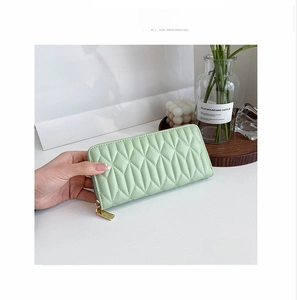 Close-up of light green quilted PU leather long wallet with golden zipper closure