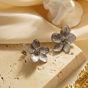 French vintage silver flower stud earrings with brushed petals on a cream stone base