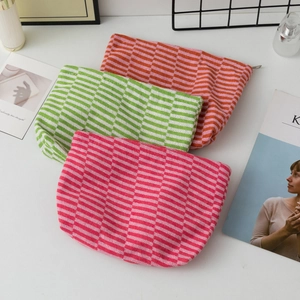 Detailed close-up of three knitted striped pouches with zipper and soft texture