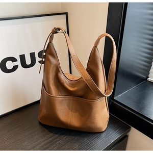 Detailed macro view of the vintage brown hobo bucket bag with leather texture and front pocket