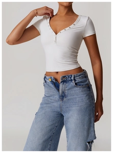 Detail of white Henley neck yoga top with metal button placket and ribbed texture
