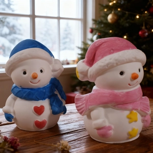 Set di statuine di pupazzi di neve natalizi con sciarpe blu e rosa su tavolo festivo
