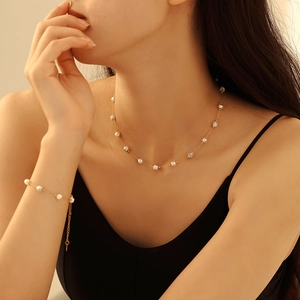 Parure collier et bracelet dorés avec perles et breloques marbre sur mannequin