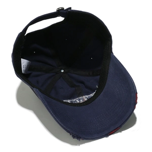 Detailed interior of navy cotton baseball cap with adjustable metal buckle and wash label