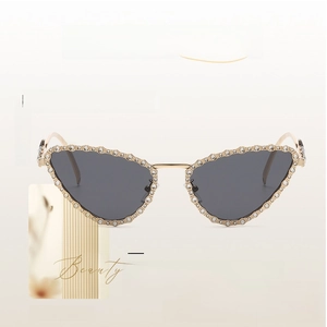 Close-up of cat-eye sunglasses featuring gold metal frame with sparkling rhinestones