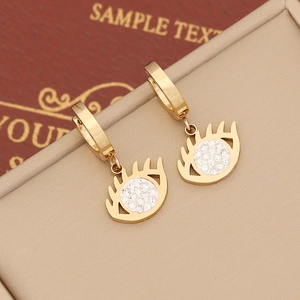Golden eye-shaped drop earrings with white zircon accents on a jewelry display box