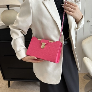 Pink woven flap crossbody bag with gold buckle and chain strap shown on model in modern room