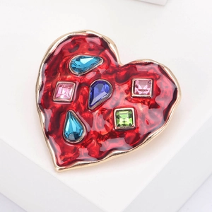 Detailed macro view of heart brooch with red enamel and colorful inlaid gemstones