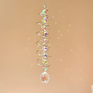 Detail of 3D spiral wind spinner with crystal ball reflecting rainbow light on wall