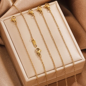 Gold stainless steel extension chains with lobster clasps hanging on a jewelry box