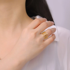 Bague en acier titane avec motif mandala géométrique ajouré doré sur le doigt