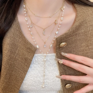 Elegant multi-layer gold necklace with celestial star moon charms and white pearls