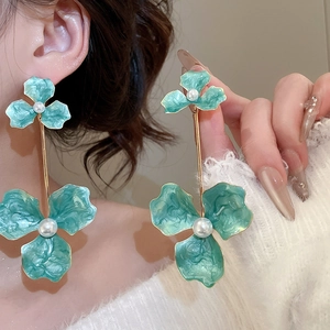 Macro shot of elegant green marble flower drop earrings with central white pearls