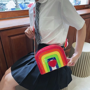Close-up of rainbow crossbody bag with heart patch and glossy patent leather finish